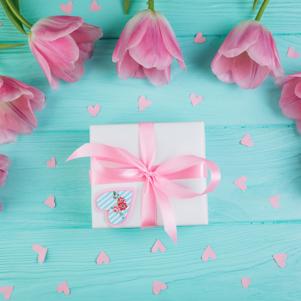 Розовые тюльпаны с подарком на голубом фоне на 8 марта