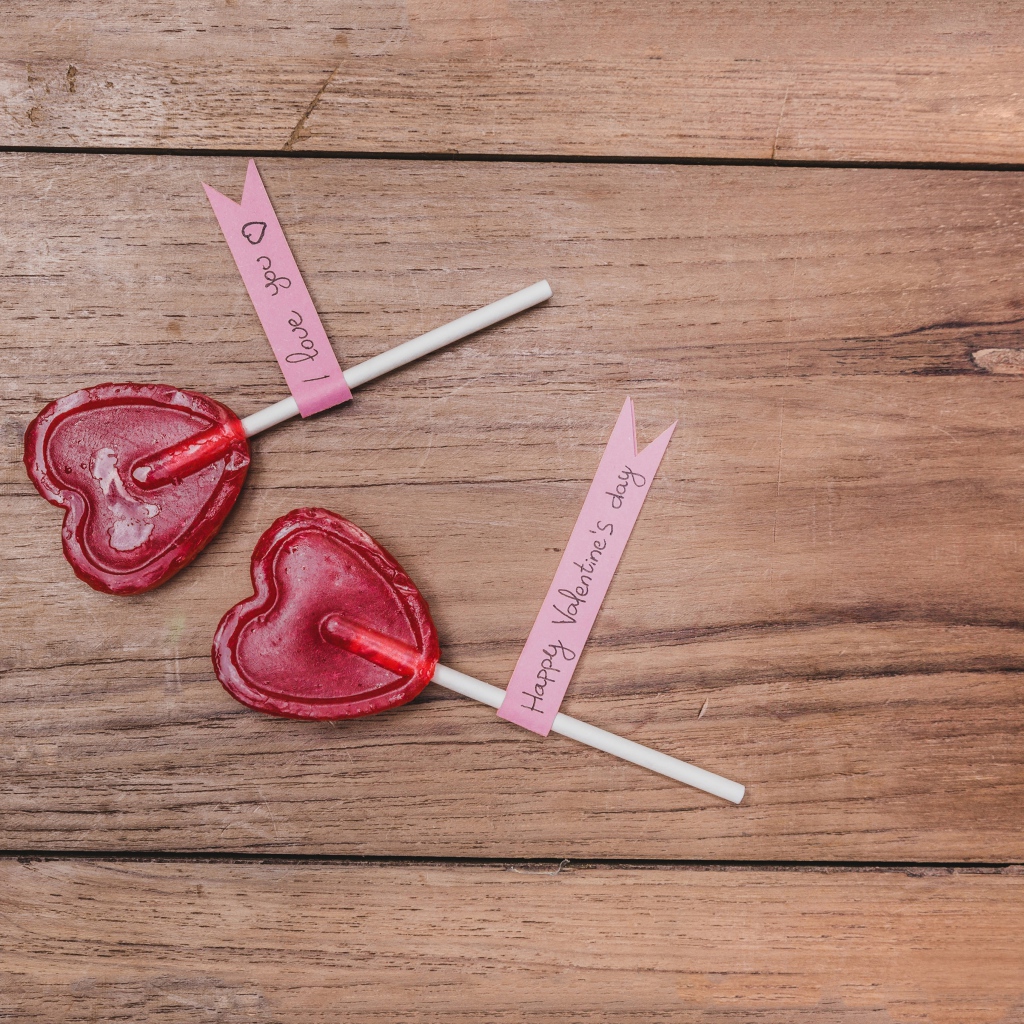 Два красных леденца для любимой на деревянном столе