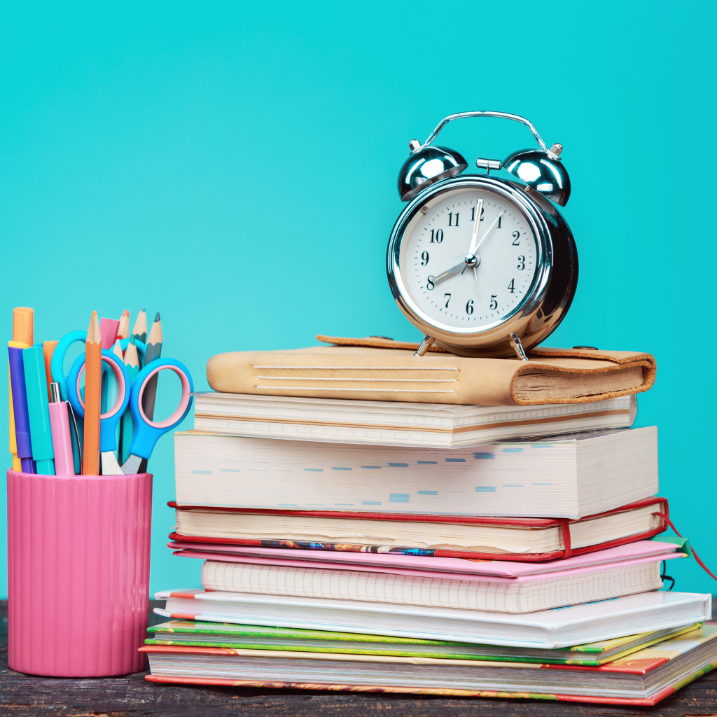 Будильник, книги и канцелярские предметы для школы