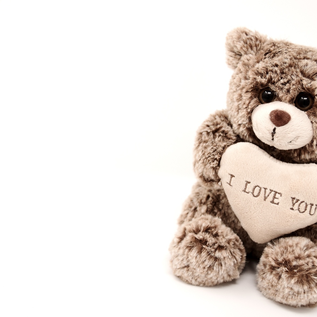 Меховая игрушка медвежонок с сердцем на белом фоне