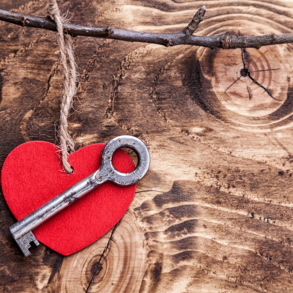 Red heart and key on a wooden table