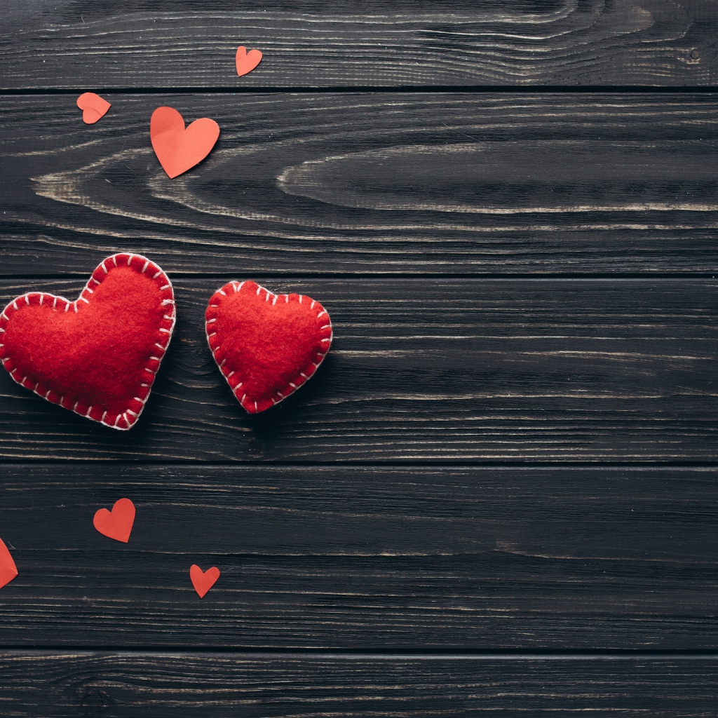 Два больших  красных сердца с маленькими  на деревянном столе 