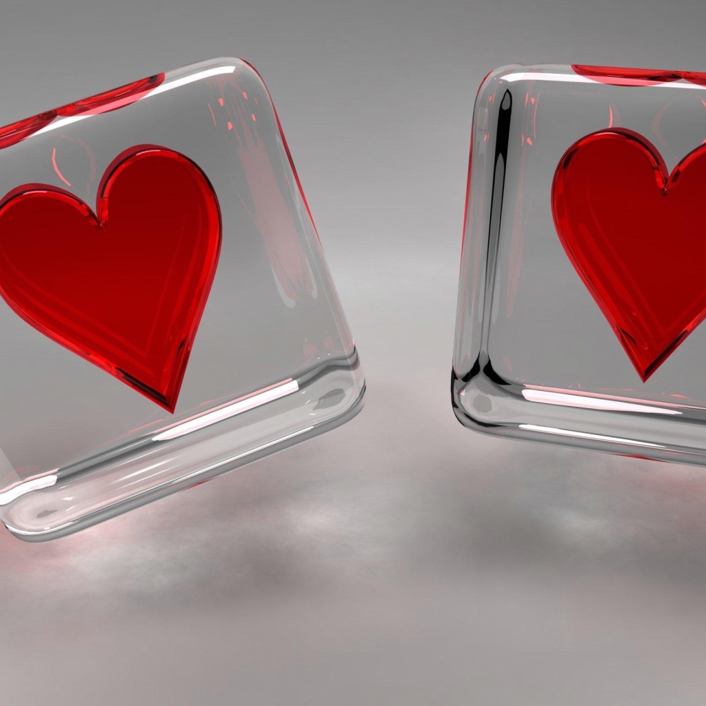 Два стеклянных кубика с сердечками на сером фоне
