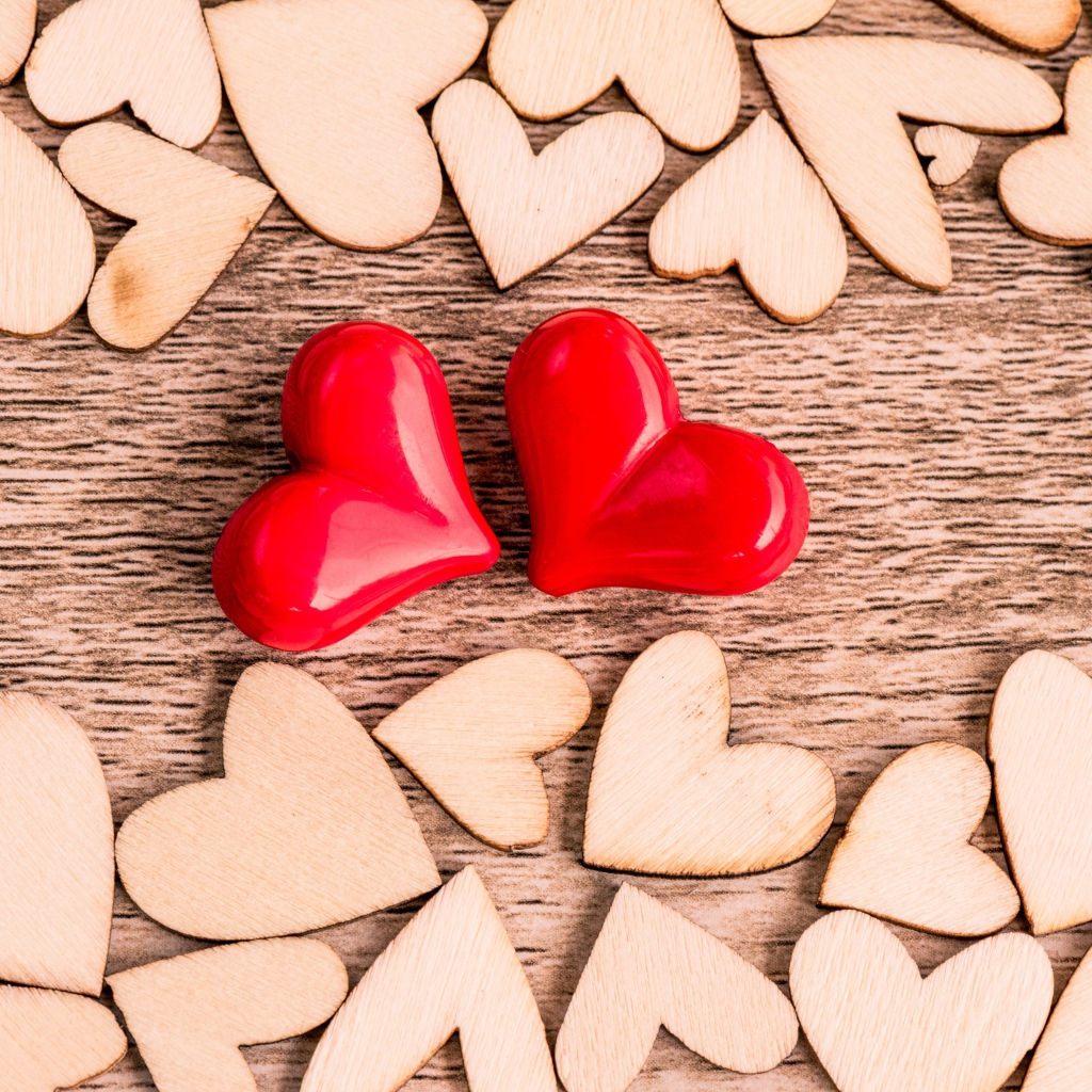 Два красных сердца и деревянные сердечки на столе