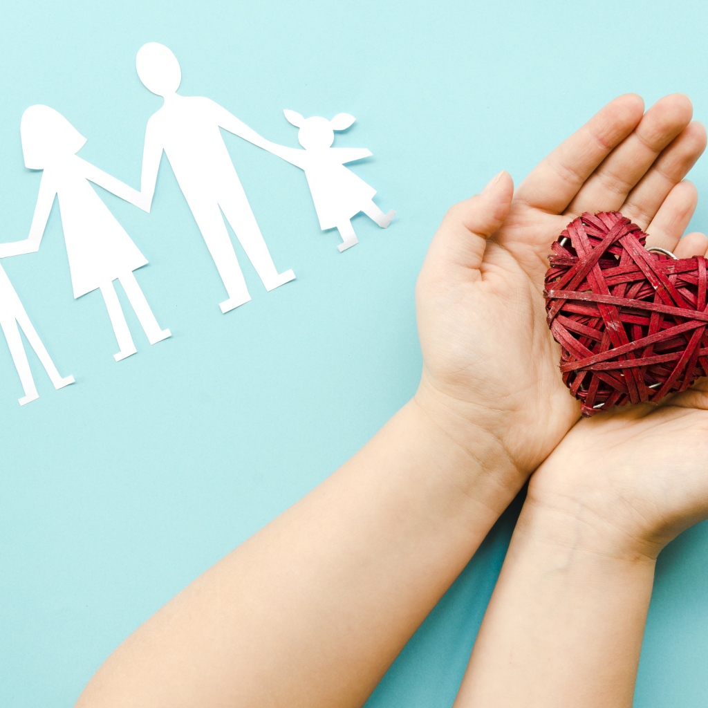 Плетеное сердце в руках на голубом фоне