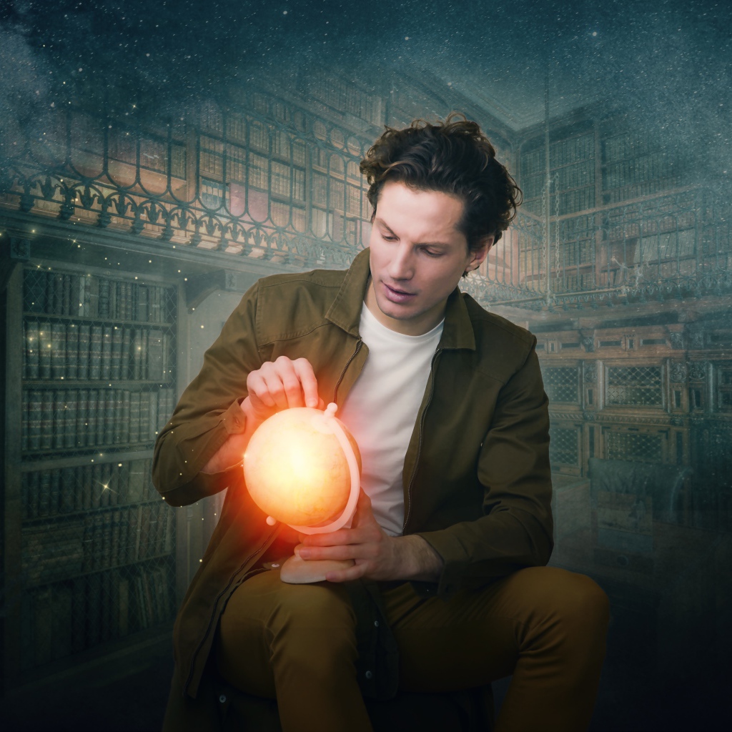 Мужчина в старой библиотеке со светящимся глобусом в руке 