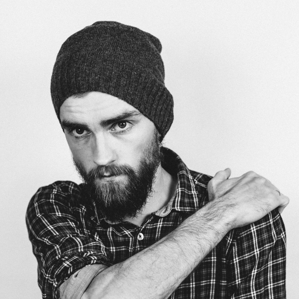 Бородатый мужчина в шапке на белом фоне 