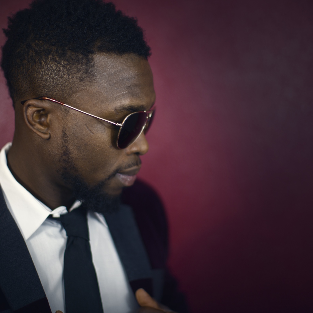 Темнокожий мужчина в костюме и очках 