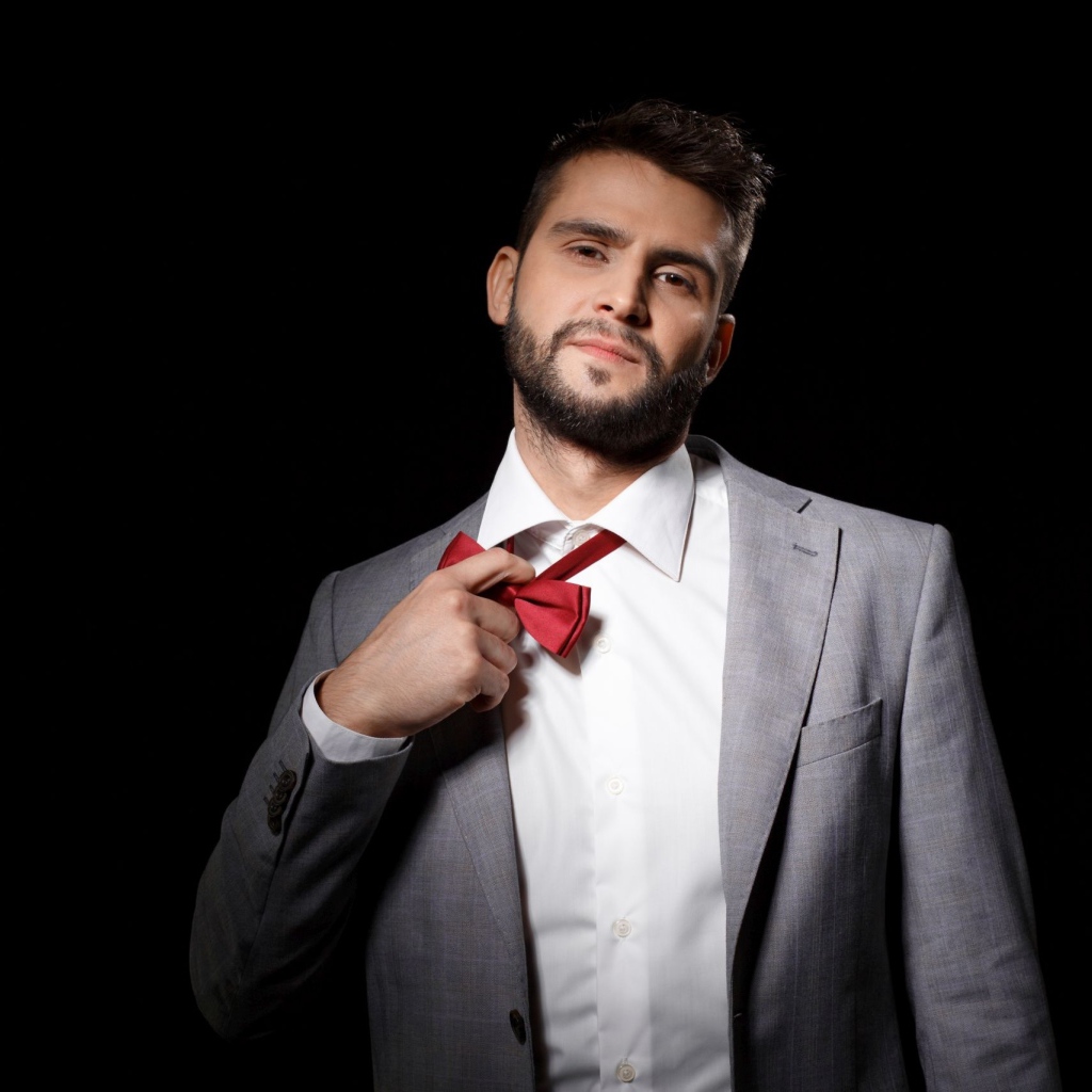 Красивый мужчина в сером пиджаке на черном фоне