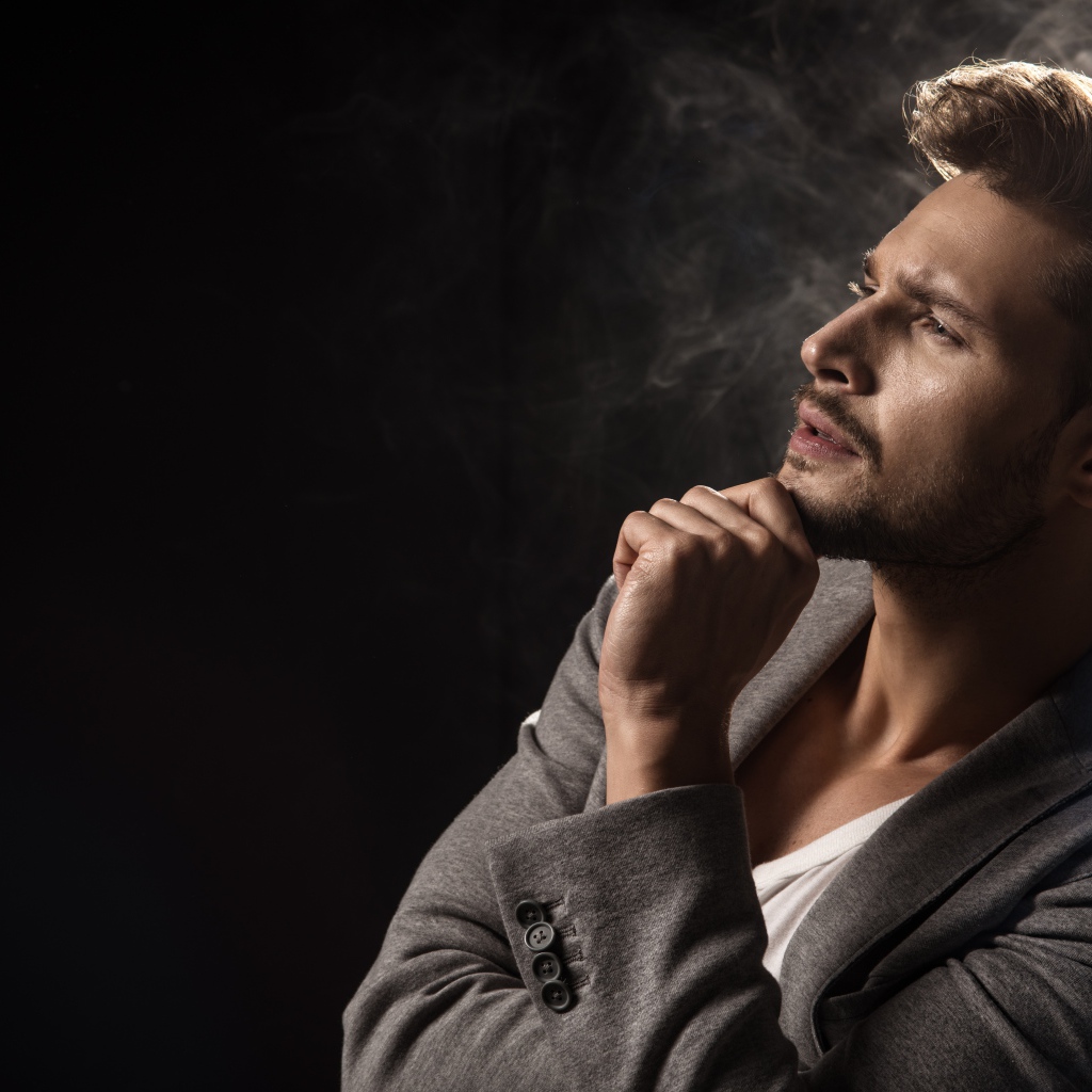 Задумчивый взгляд мужчины на черном фоне 