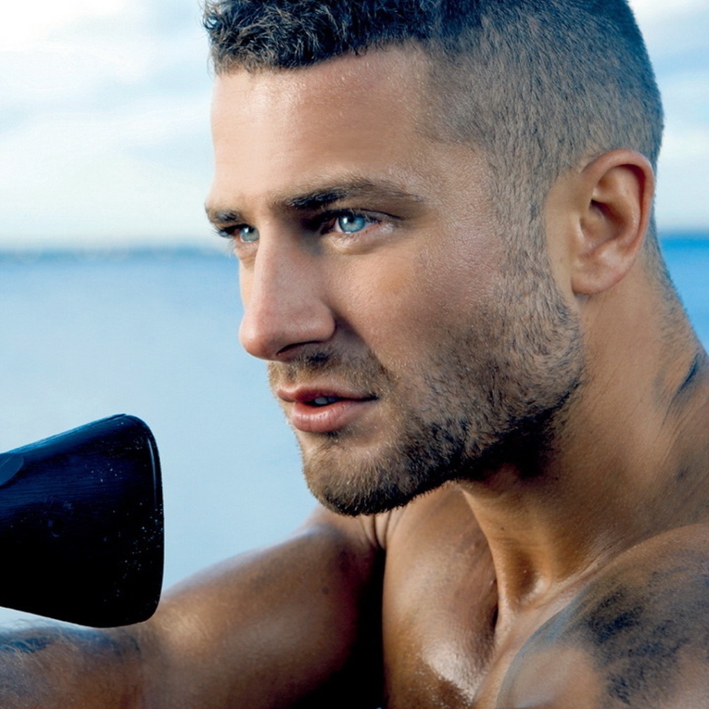 Сильный голубоглазый мужчина с винтовкой в руках 