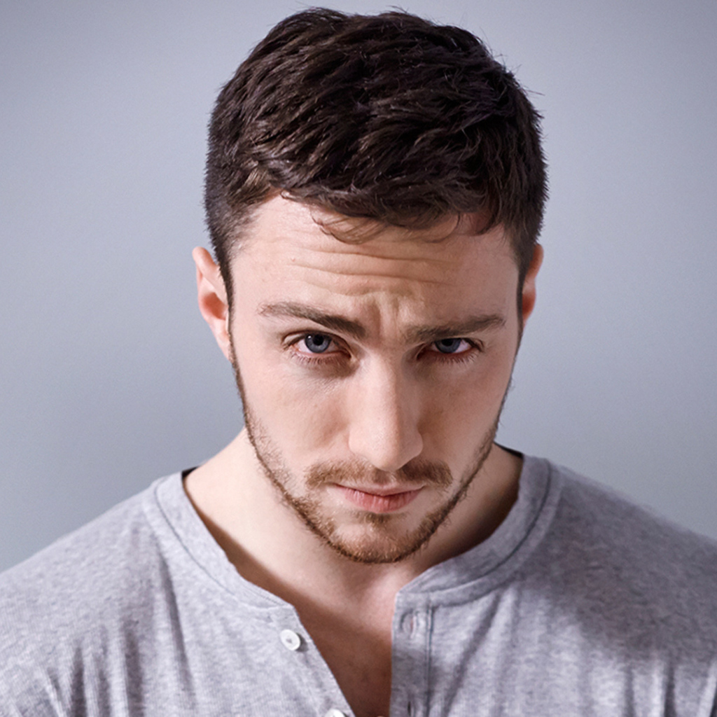 Молодой голубоглазый мужчина на сером фоне