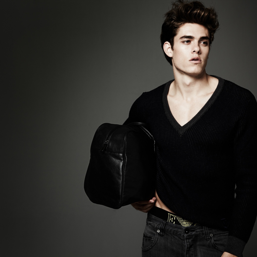 Молодой мужчина с черной сумкой в руке 