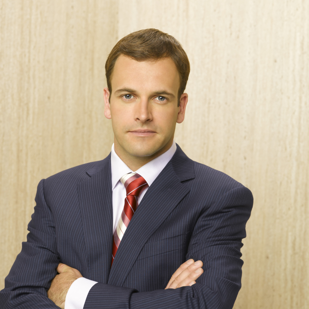 Актер Джонни Ли Миллер в костюме у стены