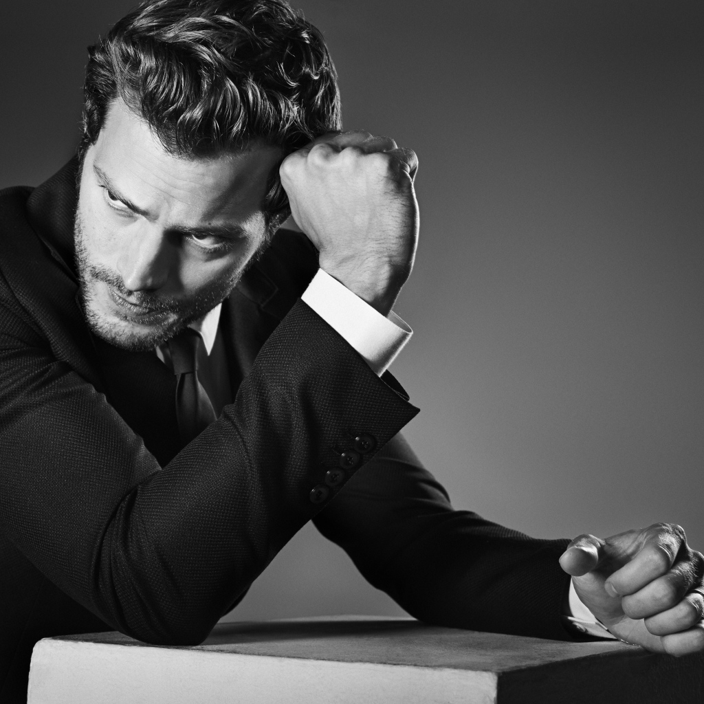 Британский актер Джейми Дорнан на сером фоне