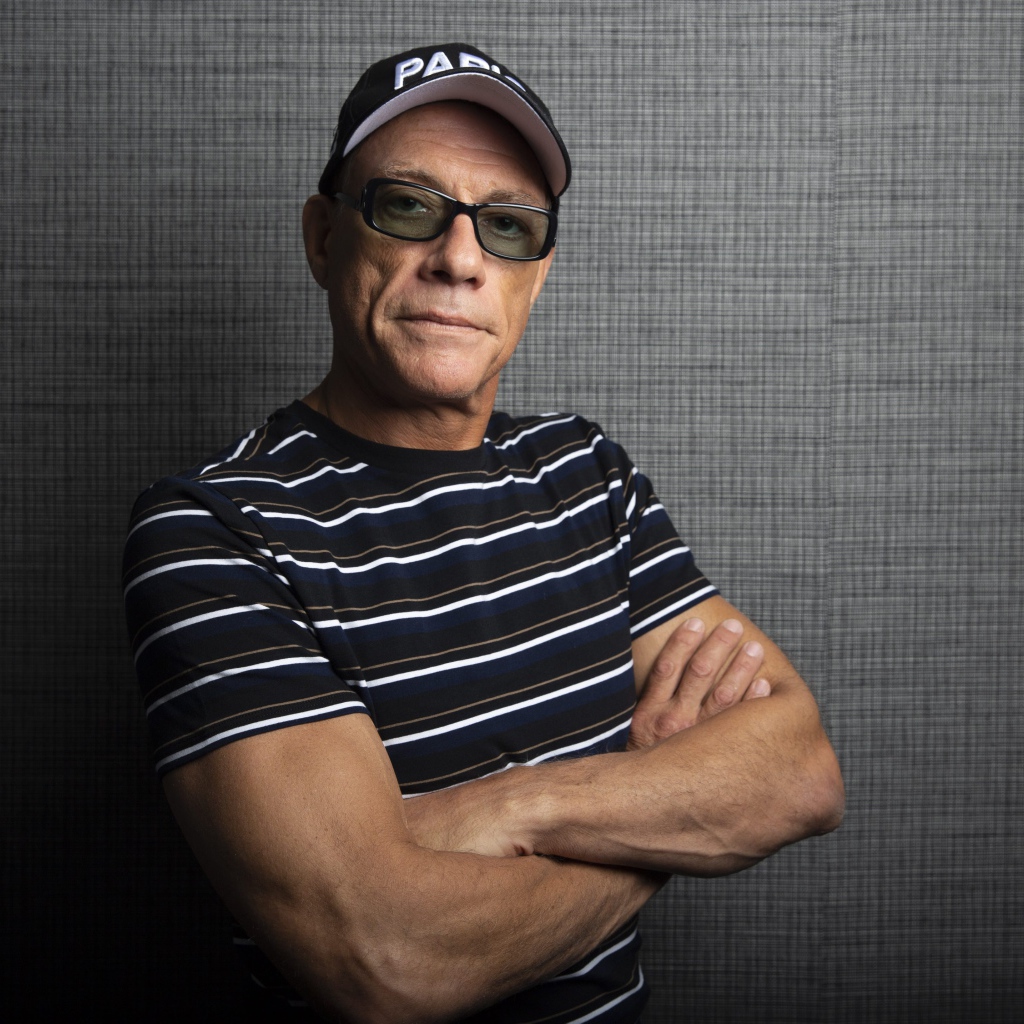 Популярный актер Жан-Клод Ван Дамм в кепке у стены