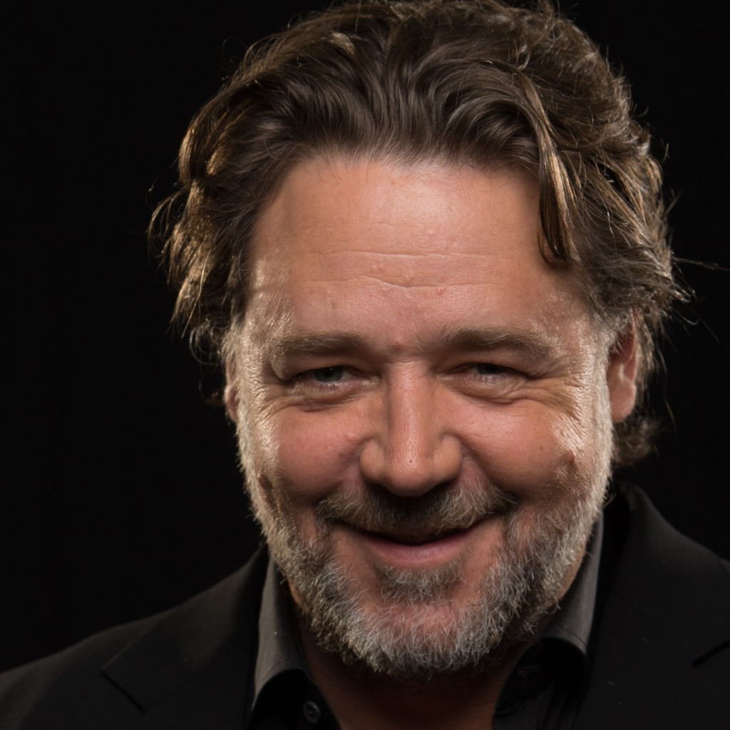 Улыбающийся Рассел Кроу на черном фоне