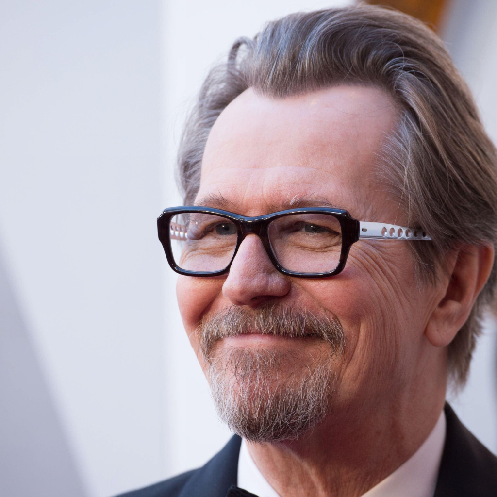 Улыбающийся мужчина, актер Гари Олдман в очках