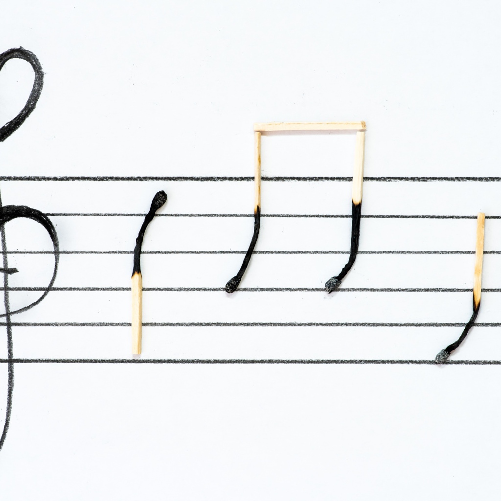 Ноты на белом фоне из сожженных спичек