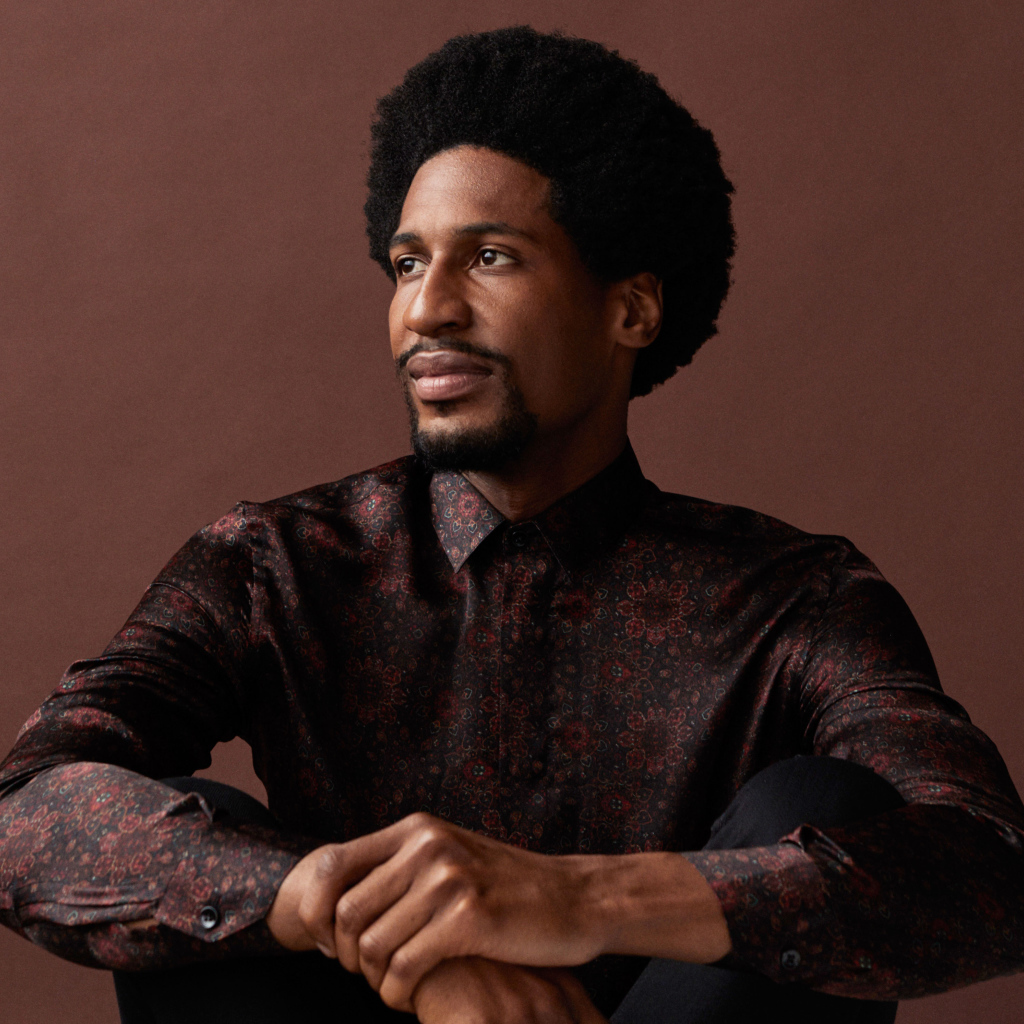 Музыкант Джонатан Батисте на коричневом фоне