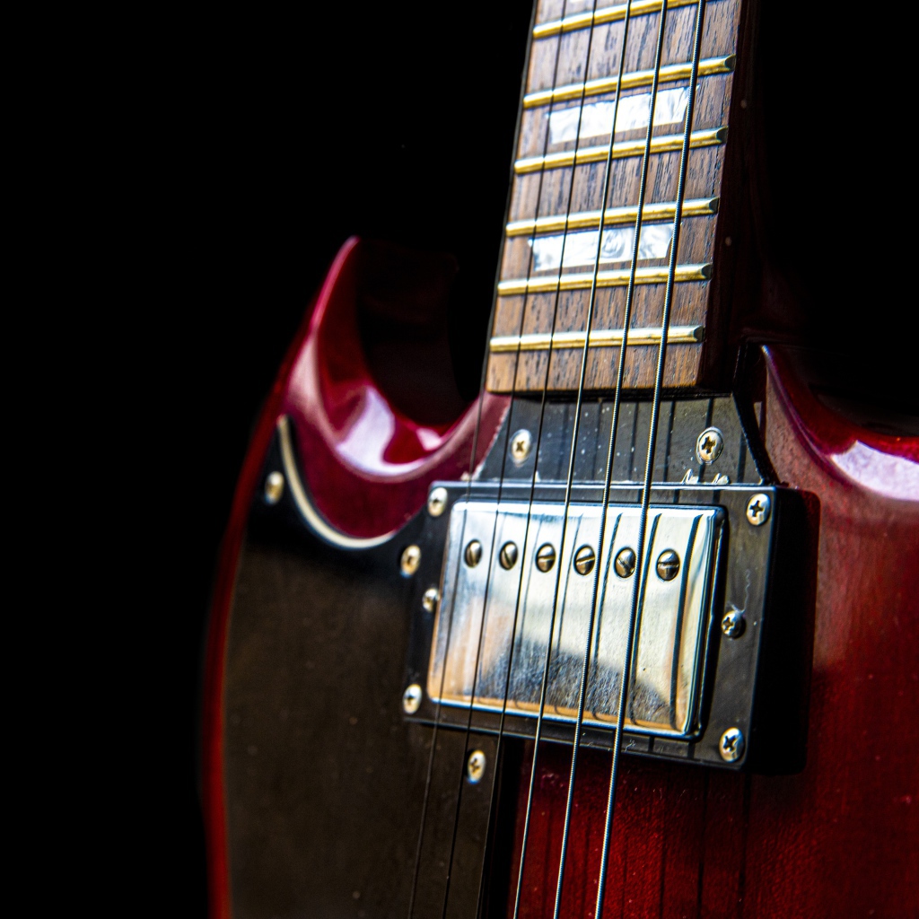 Красная гитара со струнами на черном фоне 