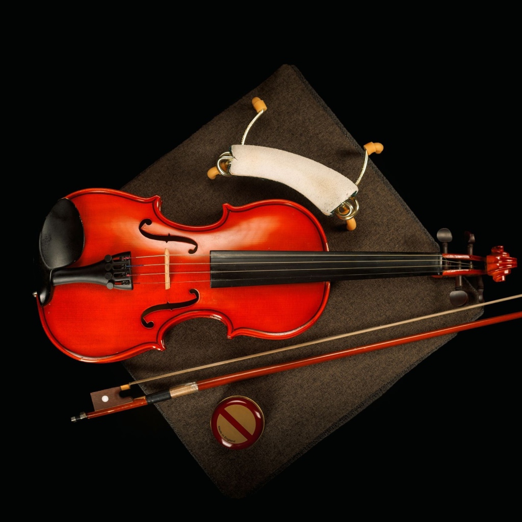 Красная скрипка со смычком на черном фоне