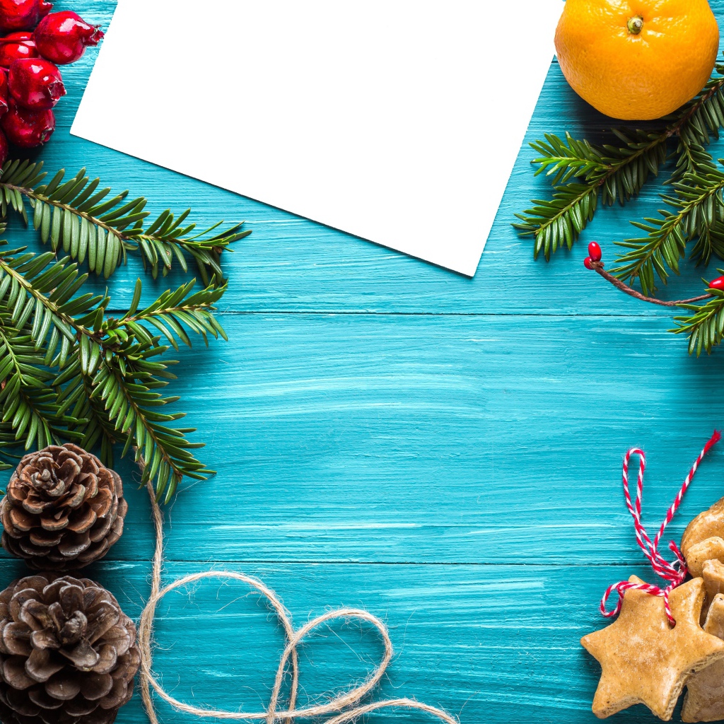 Еловые ветки с печеньем, шишками и декором на синем фоне