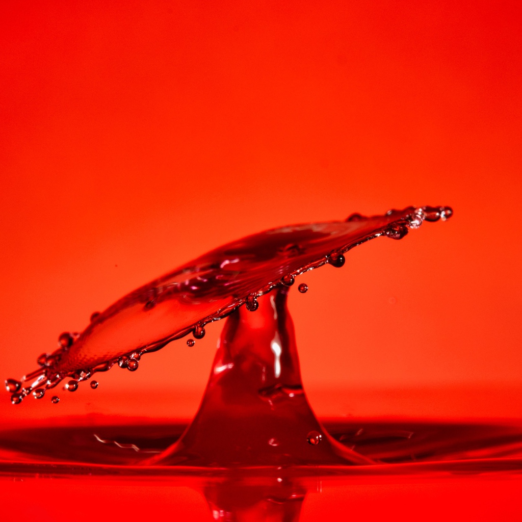 Брызги воды на красном фоне