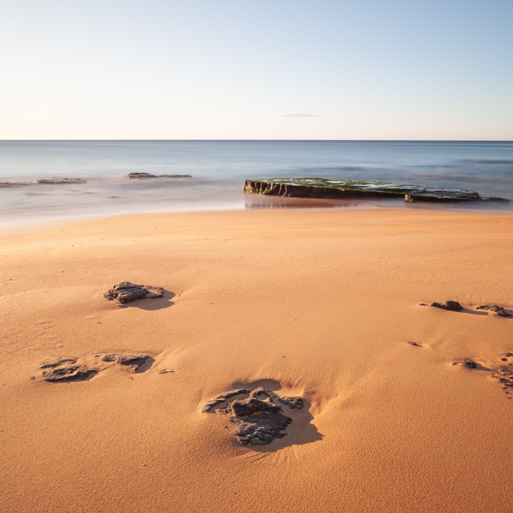 Камни в песке на берегу моря 