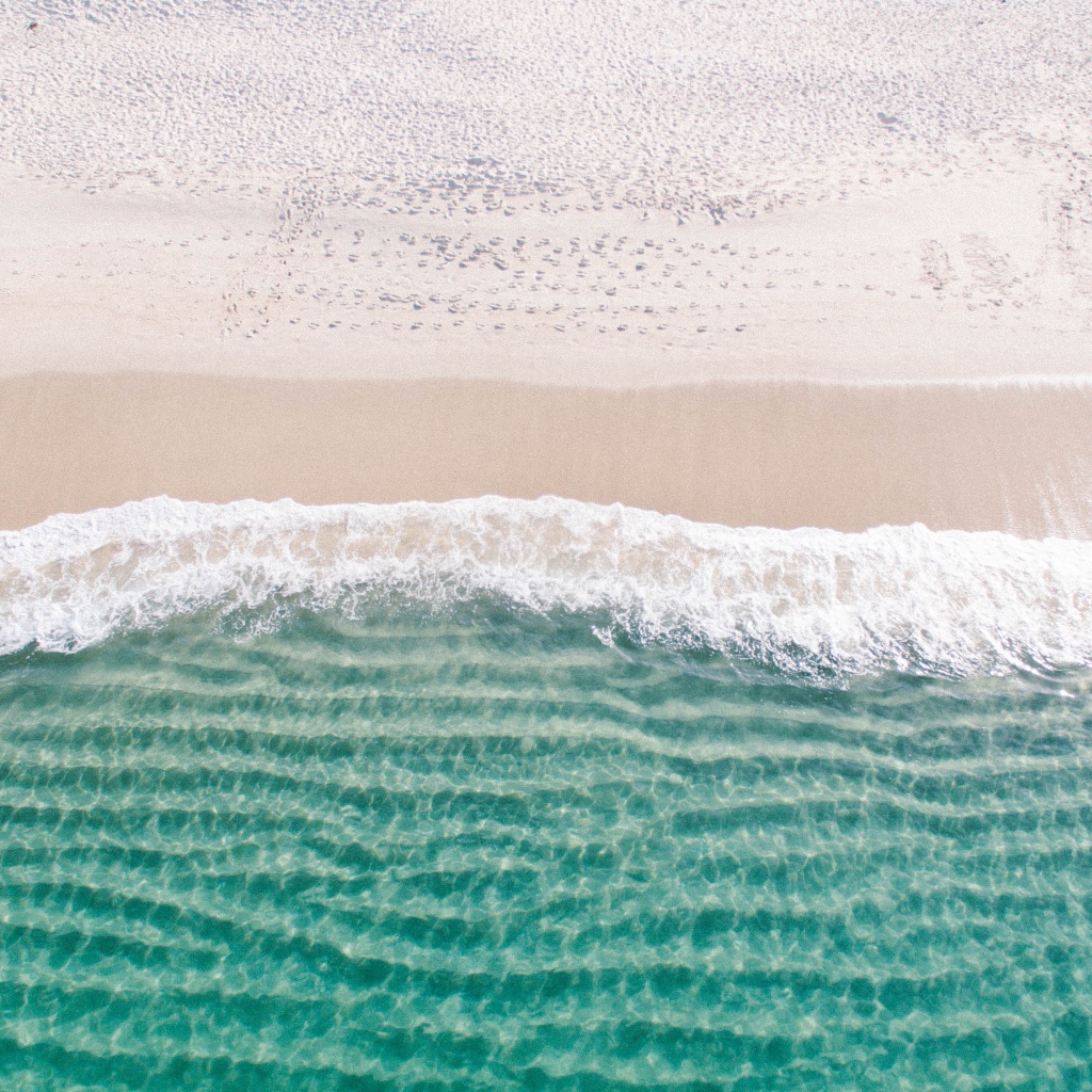 Белый морской песок на берегу у голубой воды