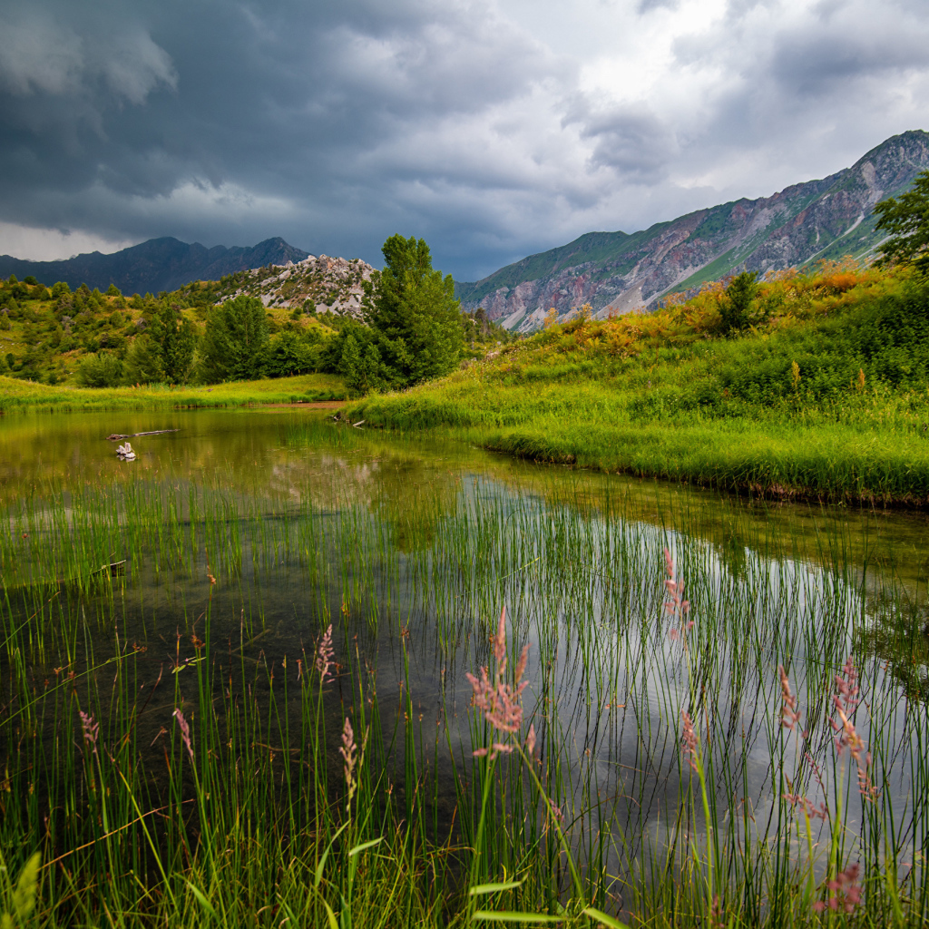 Грозовые облака над рекой в горах 