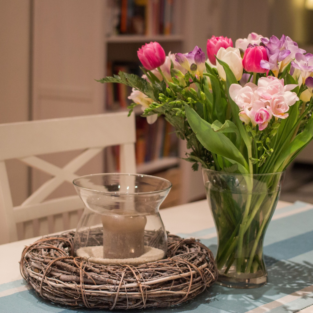 Красивый букет ярких цветов на столе со свечой