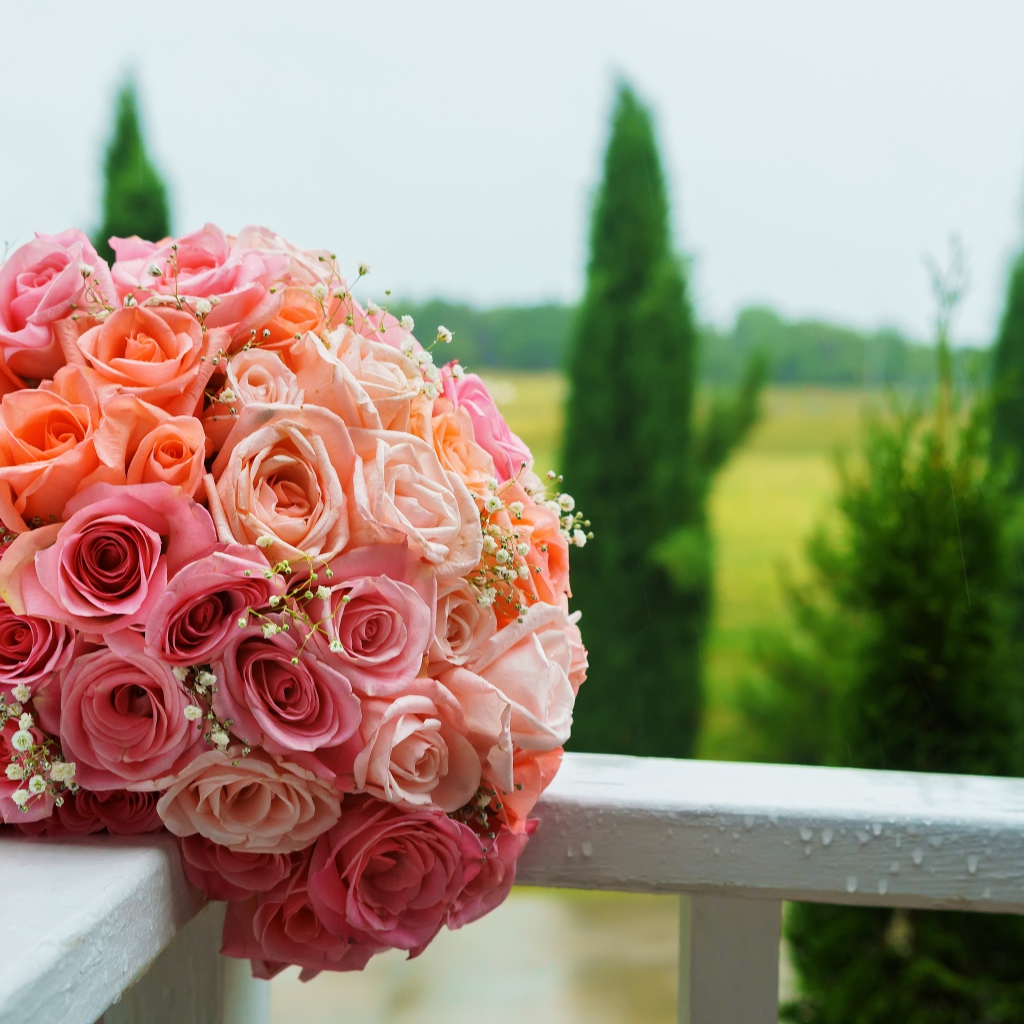 Красивый свадебный букет розовых роз на белых перилах
