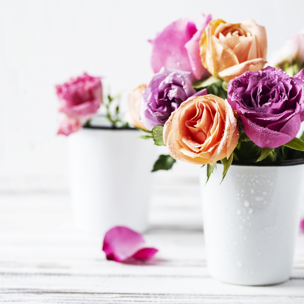 Букет разноцветных роз в белой вазе на столе