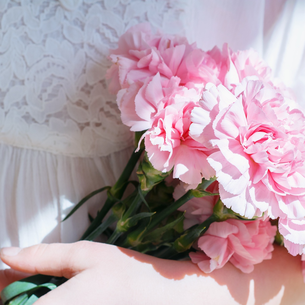 Букет розовых цветов гвоздики в руках у невесты