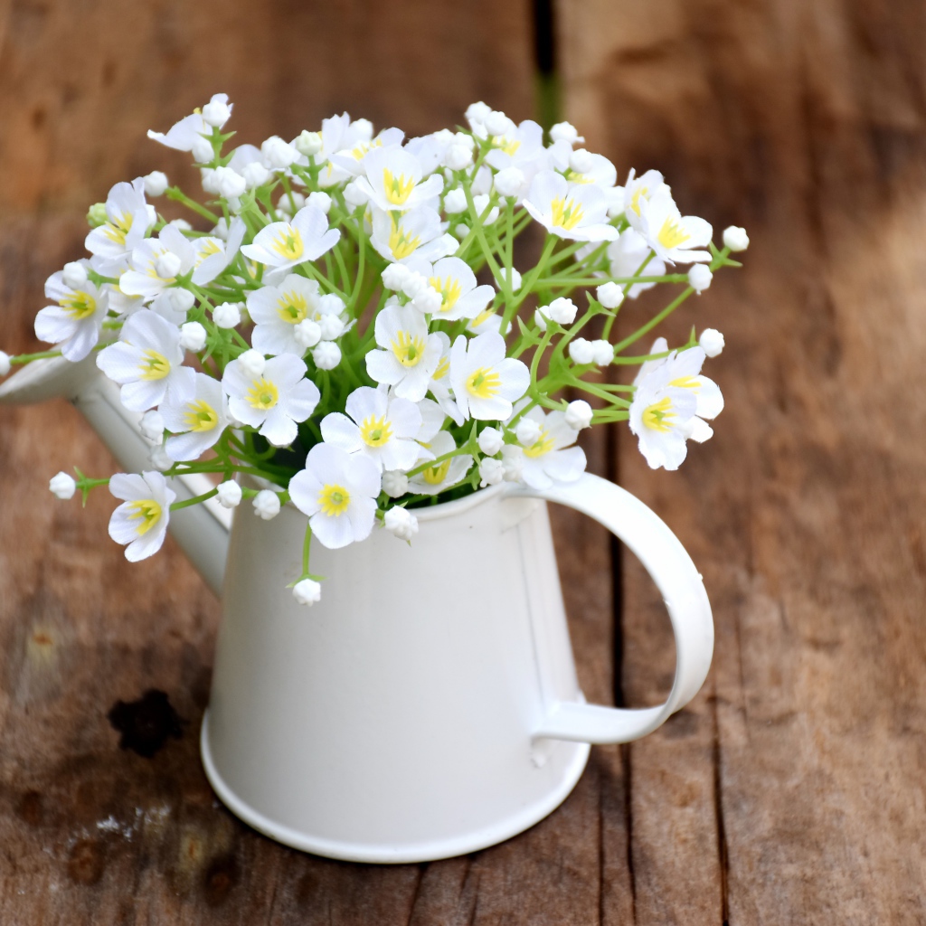 Маленькие белые цветы гипсофила в вазе на столе