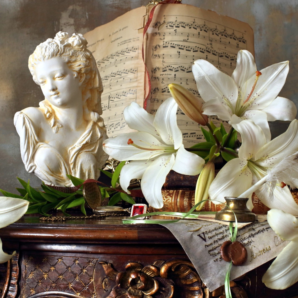Белые лилии, статуя и ноты лежат на столе