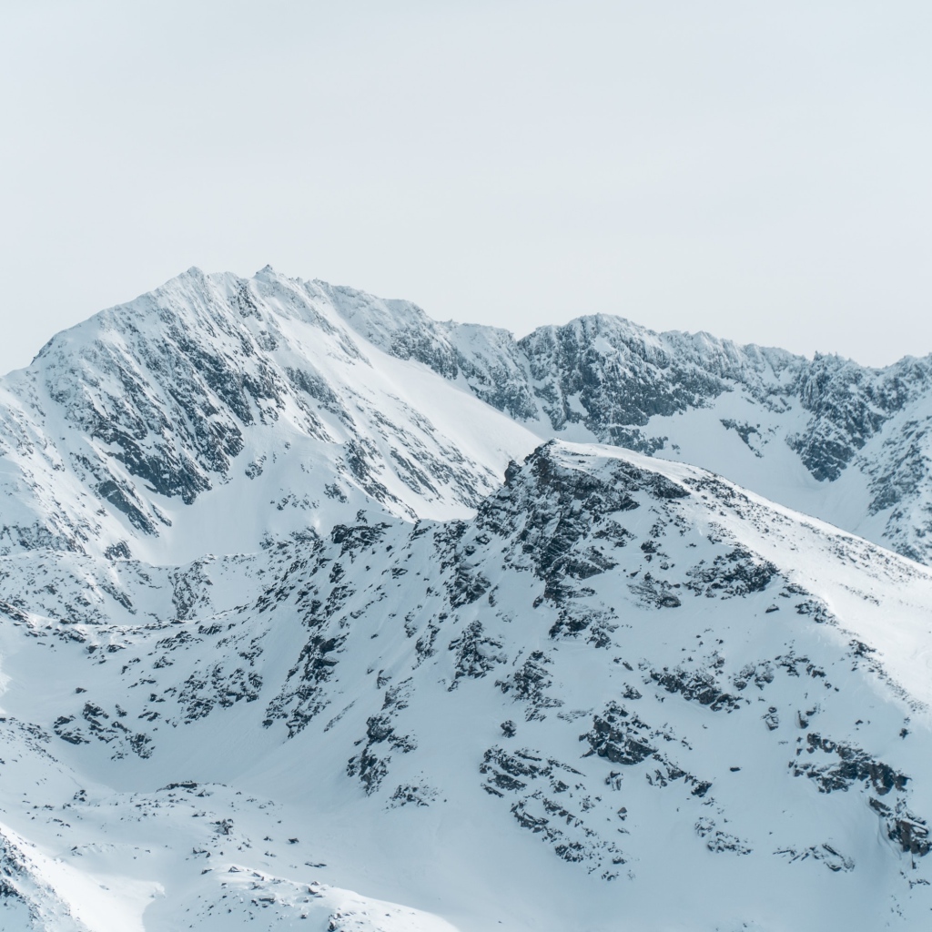 Заснеженная гора под серым небом 