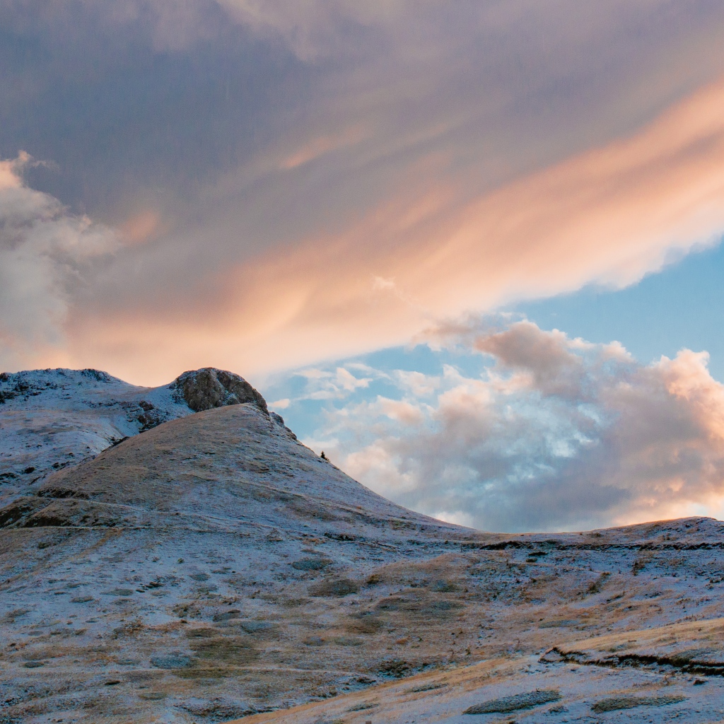 Красивые серые облака над заснеженной горой 