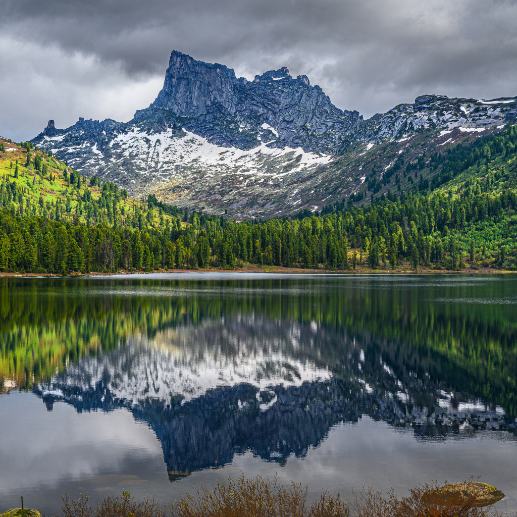 Красивая гора под грозовым небом отражается в озере 