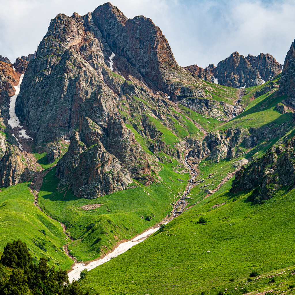 Большие каменные горы с зеленым ковром травы