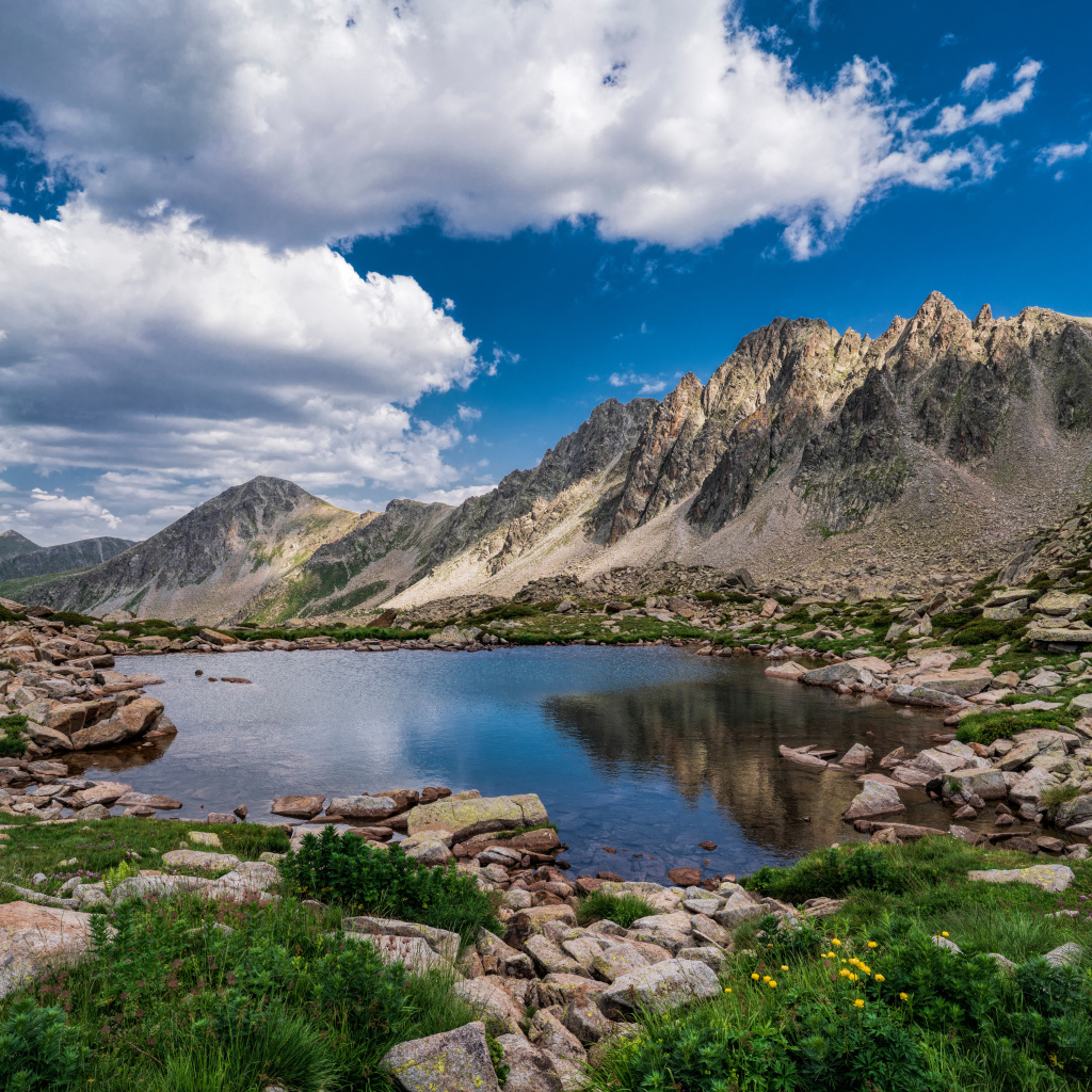 Горы под голубым небом с белыми облаками у озера, Андорра 