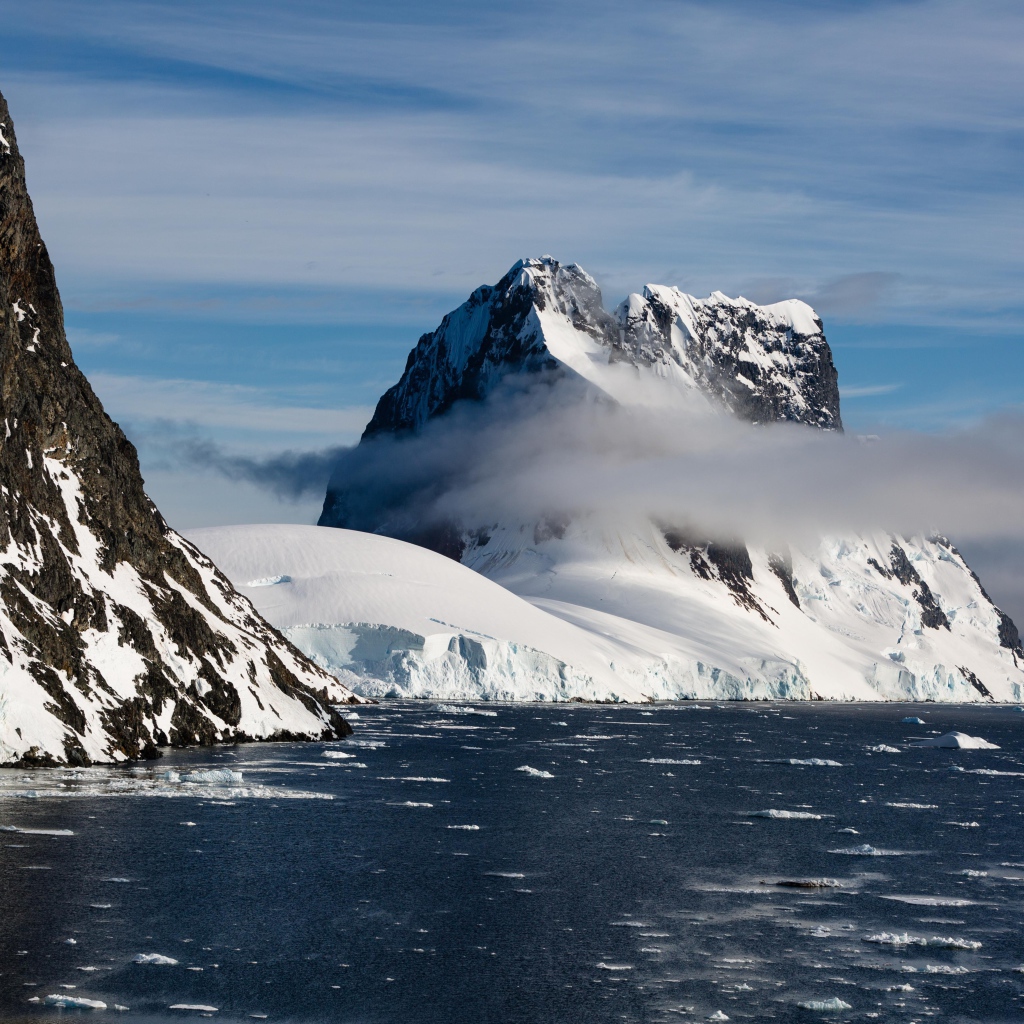 Заснеженные горы у покрытого льдом океана 