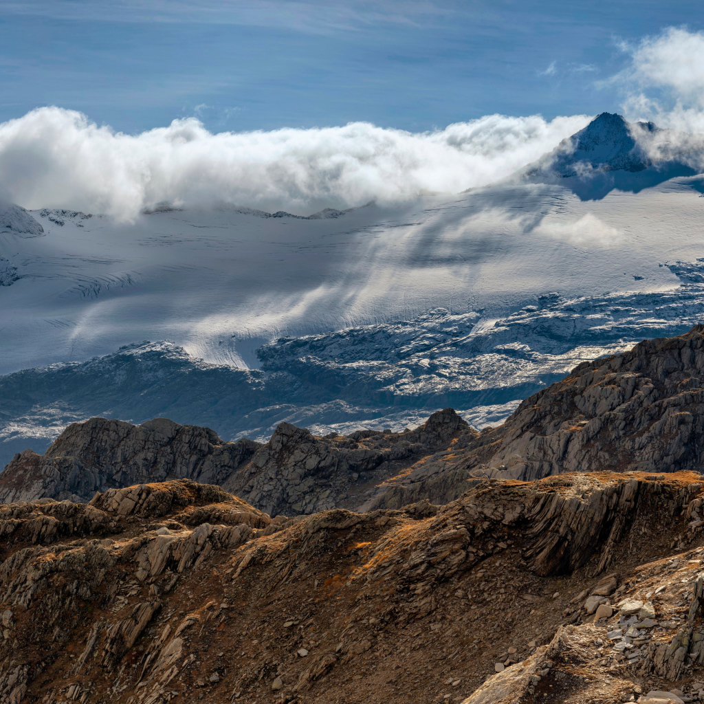 Густые белые облака над заснеженными Альпами