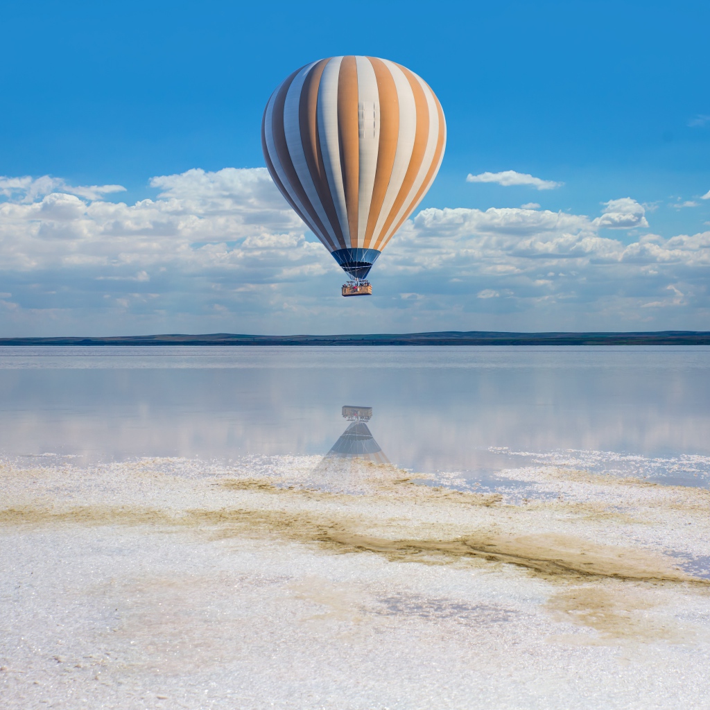 Большой воздушный шар летит на водой