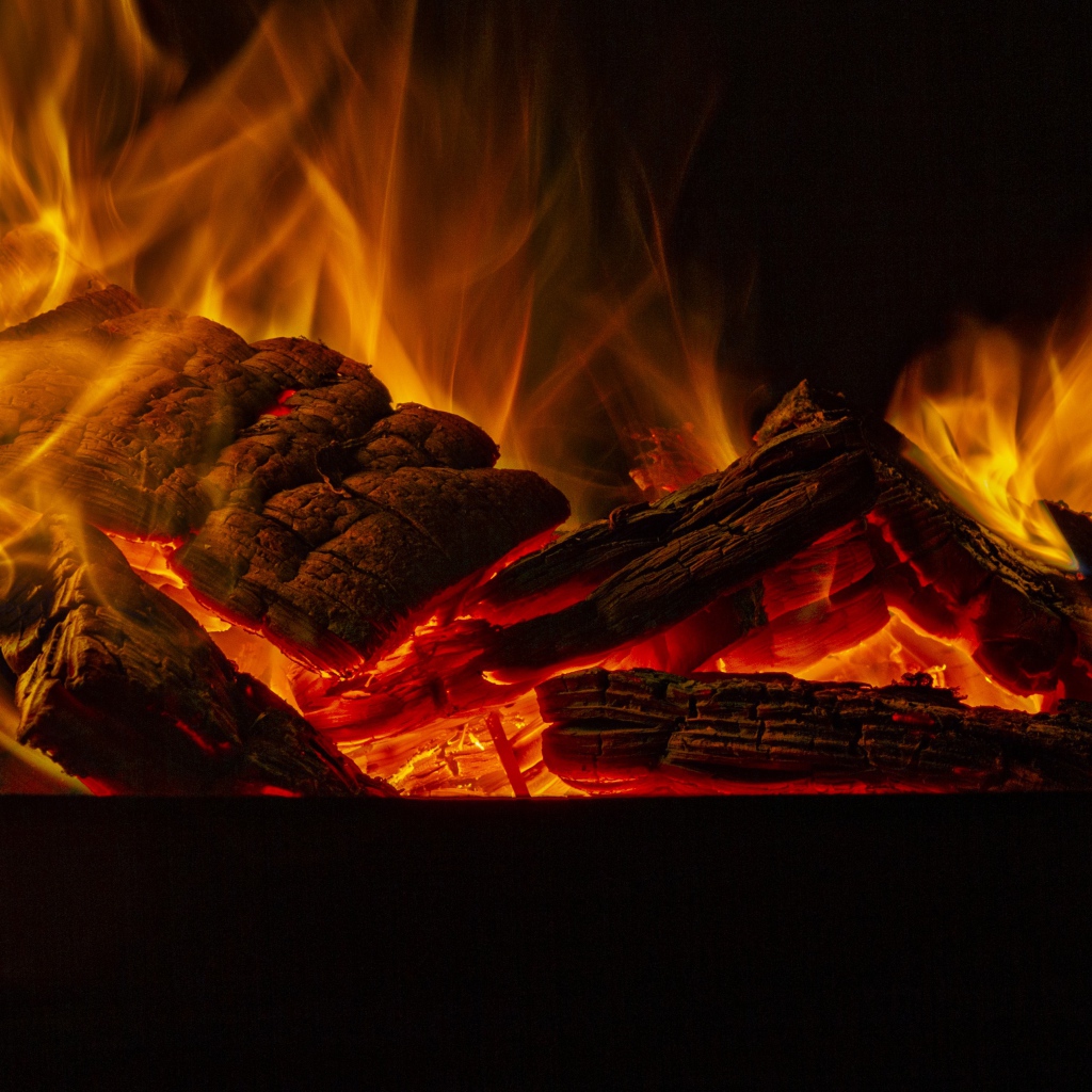Дрова горят желтым пламенем в камине