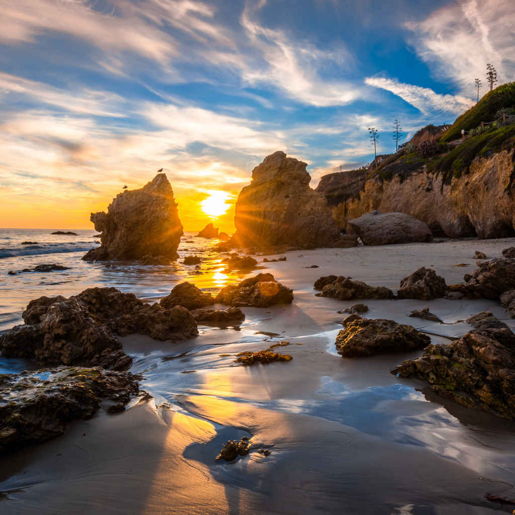 Яркий рассвет летнего солнца над скалами и океана