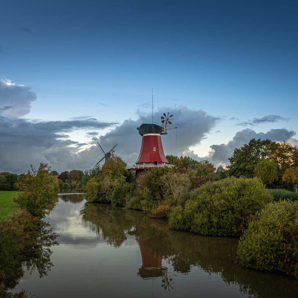 Мельница на берегу реки под красивым небом в сумерках