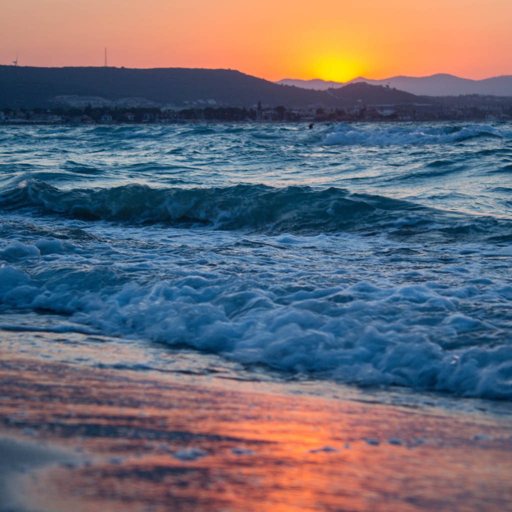 Бушующие волны на берегу моря на закате 
