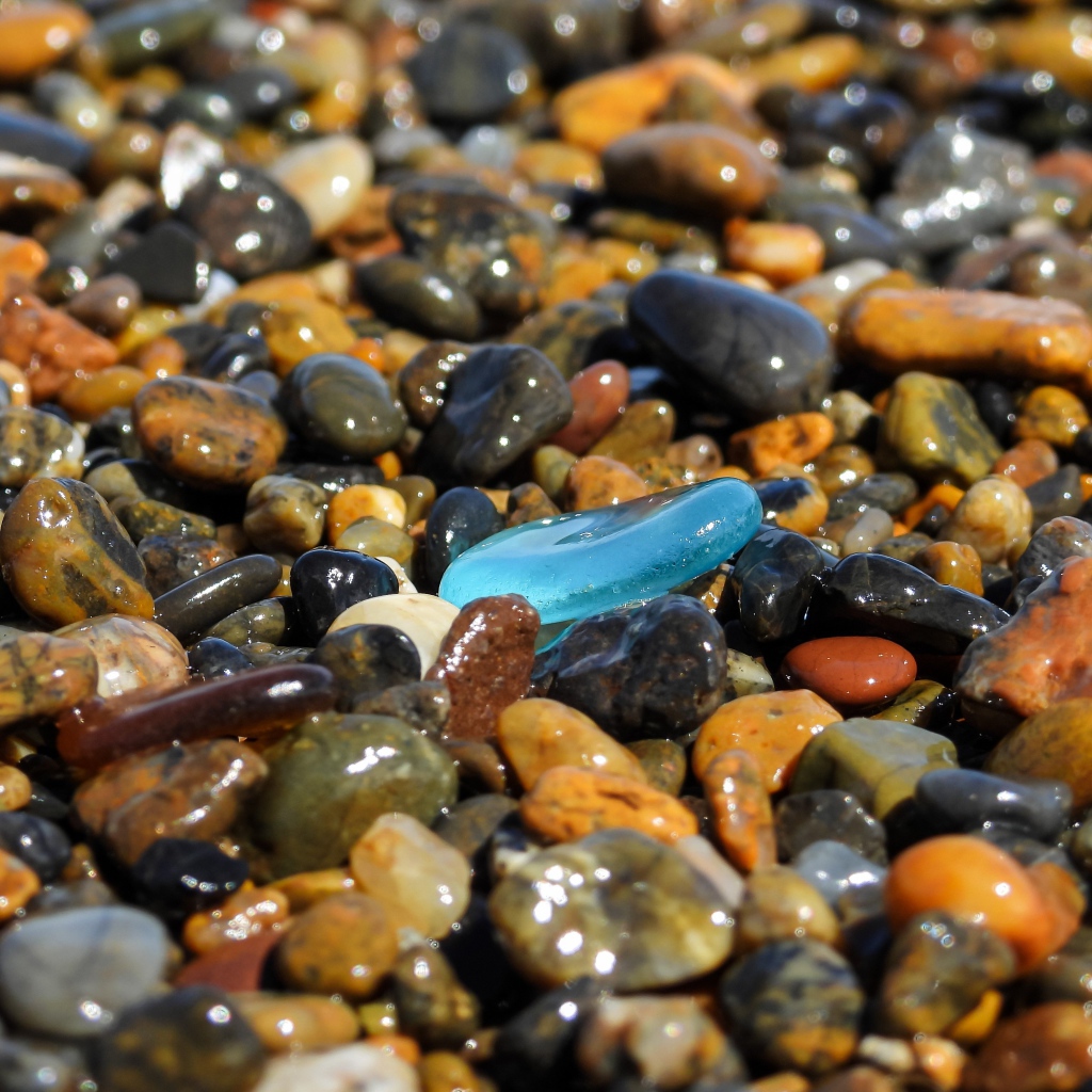 Гладкие разноцветные мелкие камни на пляже 